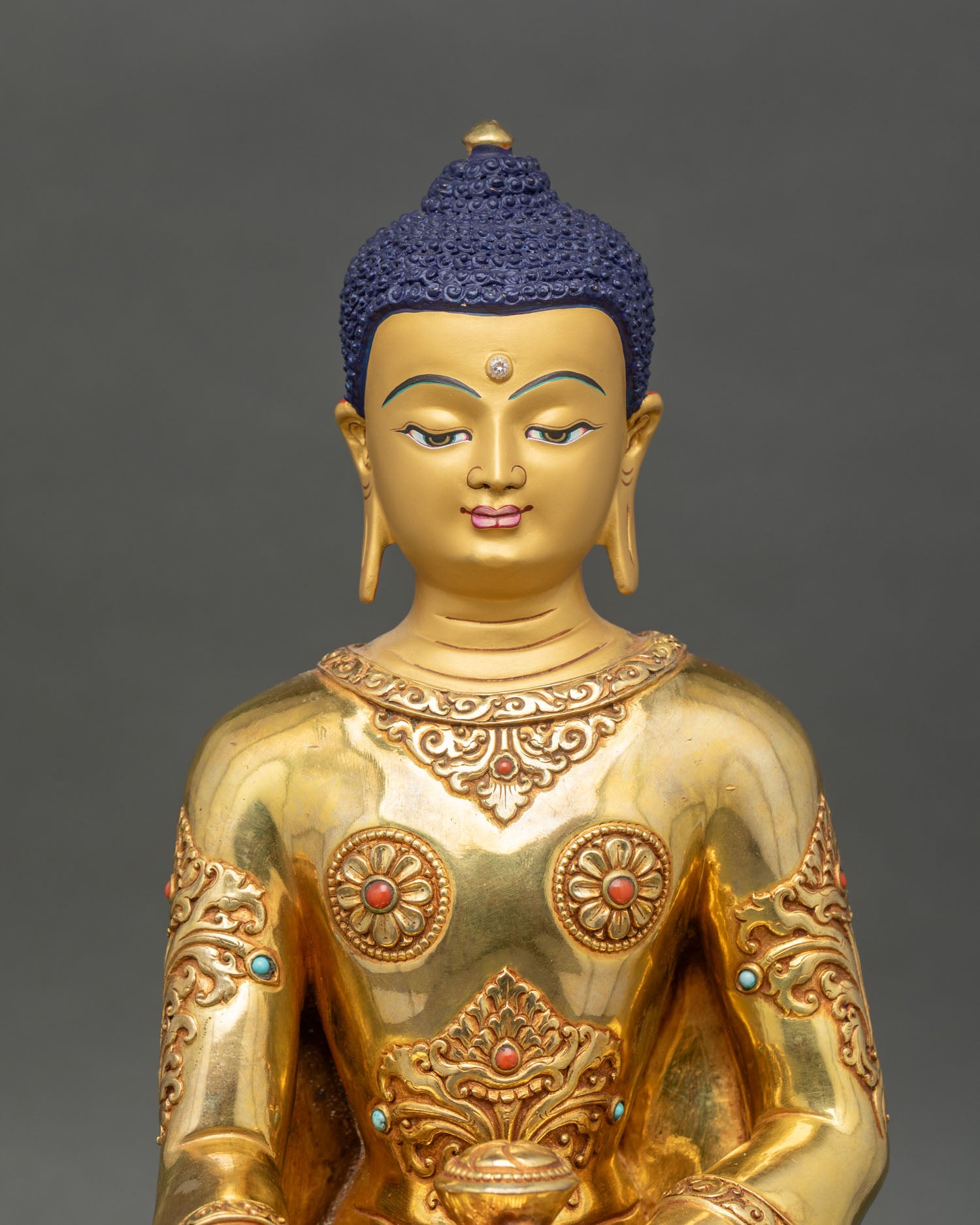 Close up Shakyamuni Buddha gold painted face turquoise coral stone inlays