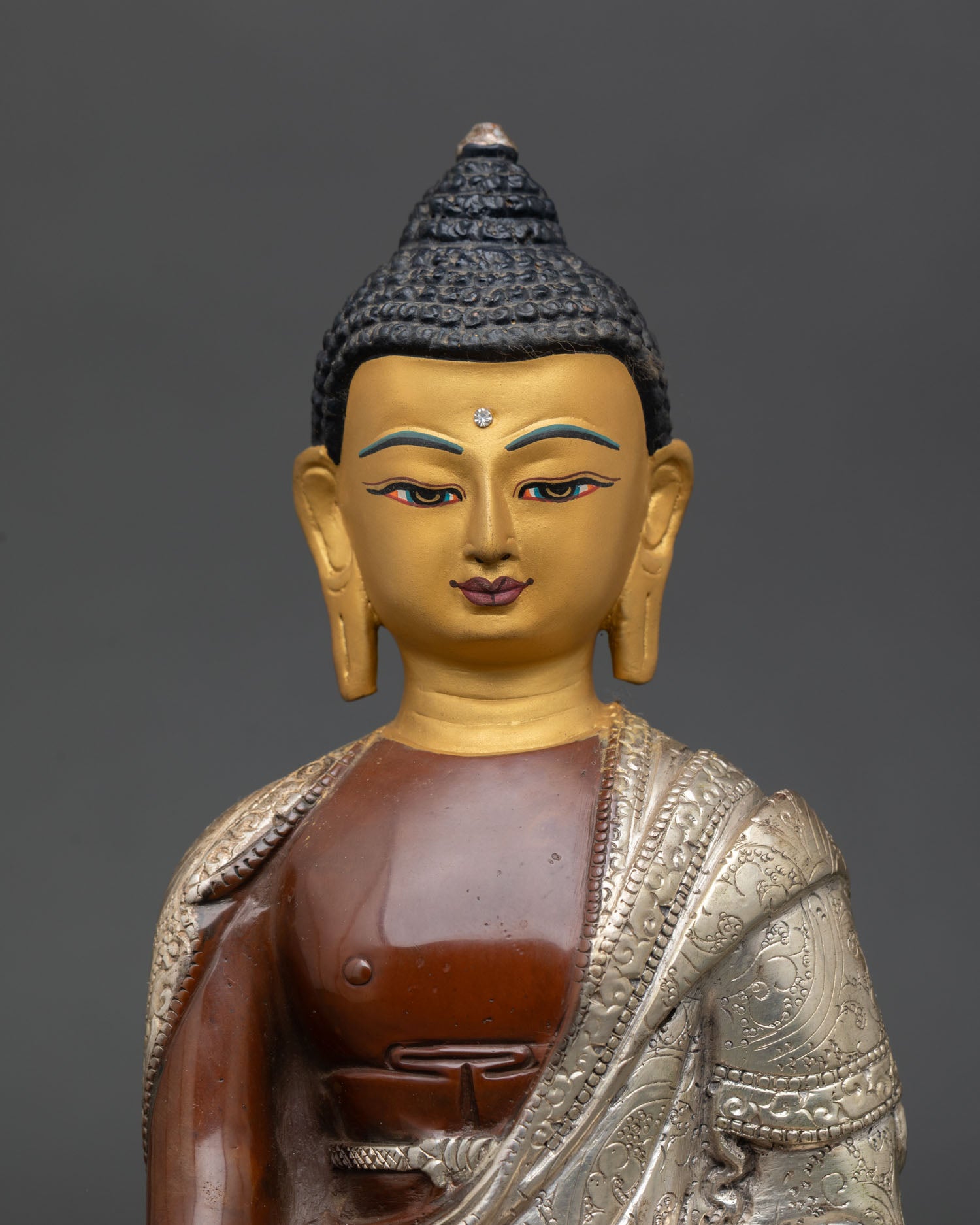 Close up Shakyamuni Buddha gold painted face with serene Himalayan detailing