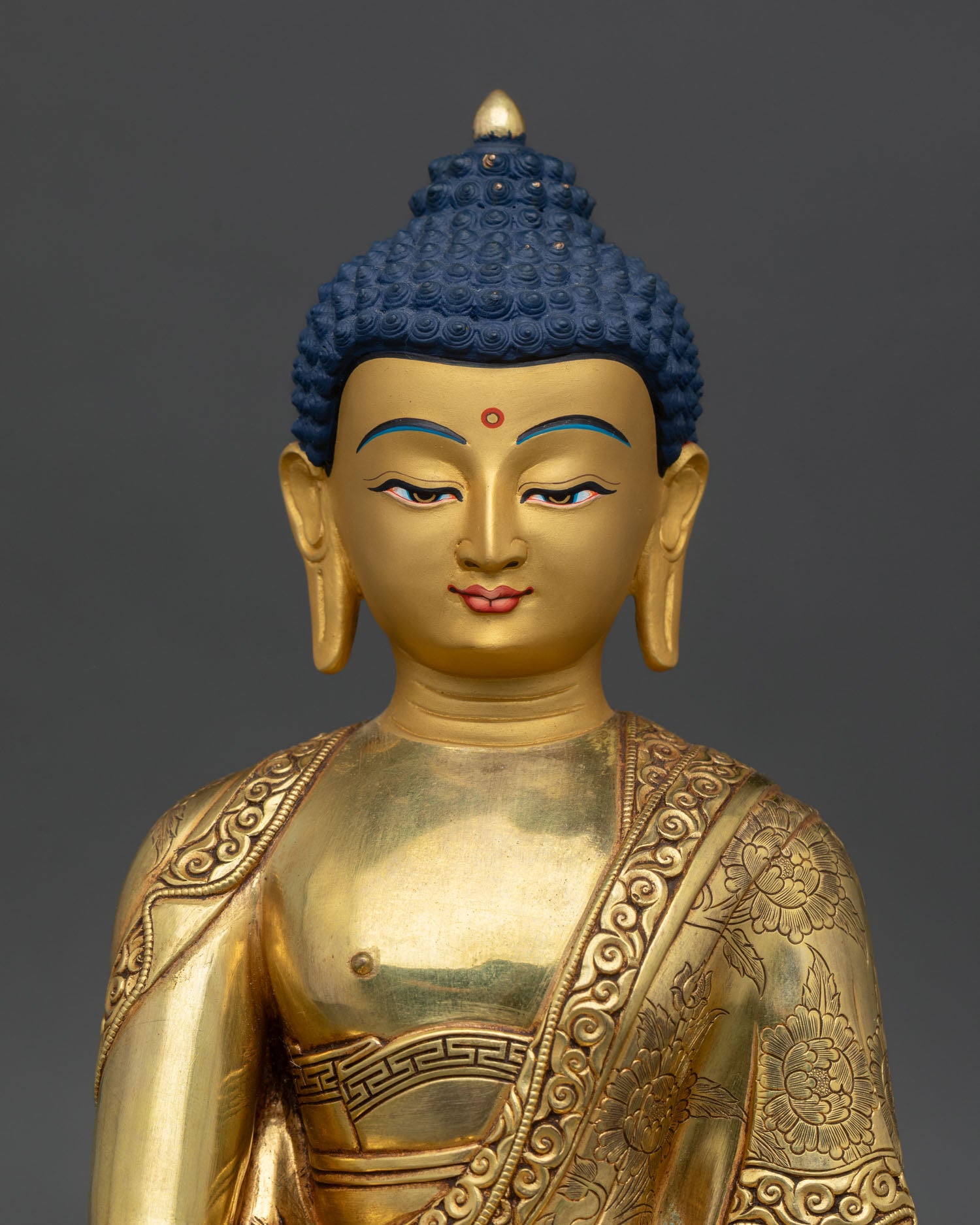 Close up Shakyamuni Buddha serene gold finished face Nepalese artisan craftsmanship lost wax casting spiritual sculpture radiant calm expression