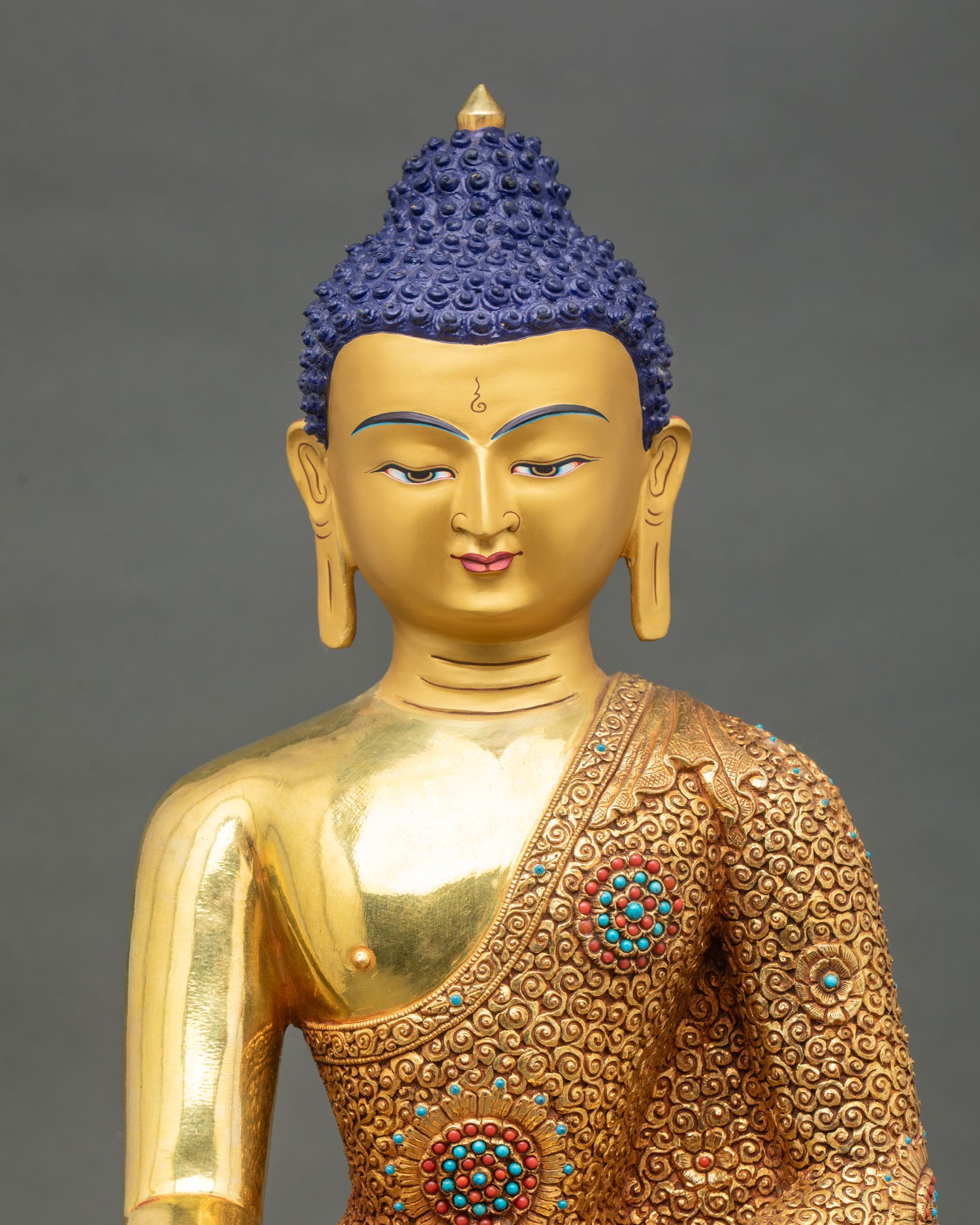 Close-up of Shakyamuni Buddha statue showing intricate copper and gold details