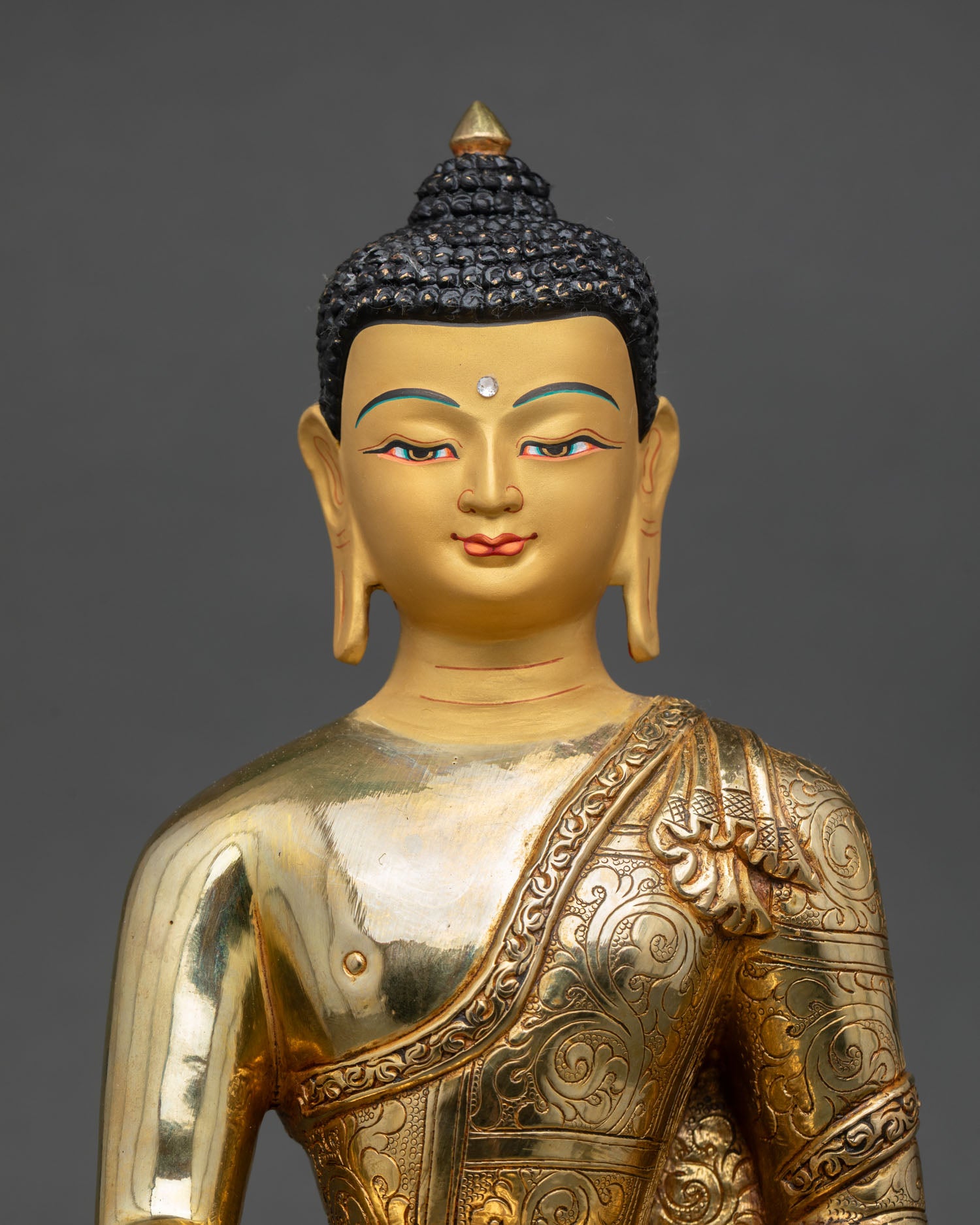 Close up Shakyamuni Buddha statue with delicately gold painted face and intricate Himalayan artisan craftsmanship details