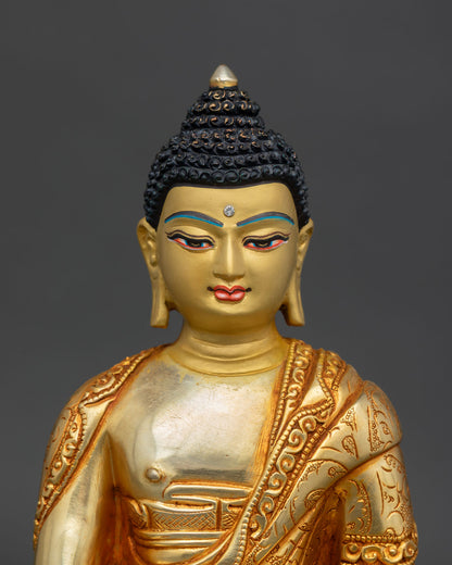 Close up Shakyamuni Buddha statue with serene gold painted face copper Himalayan Buddhist artwork lost wax casting detail