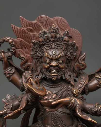 Close up Six Armed Mahakala face with third eye tiger skin garment and ritual objects.