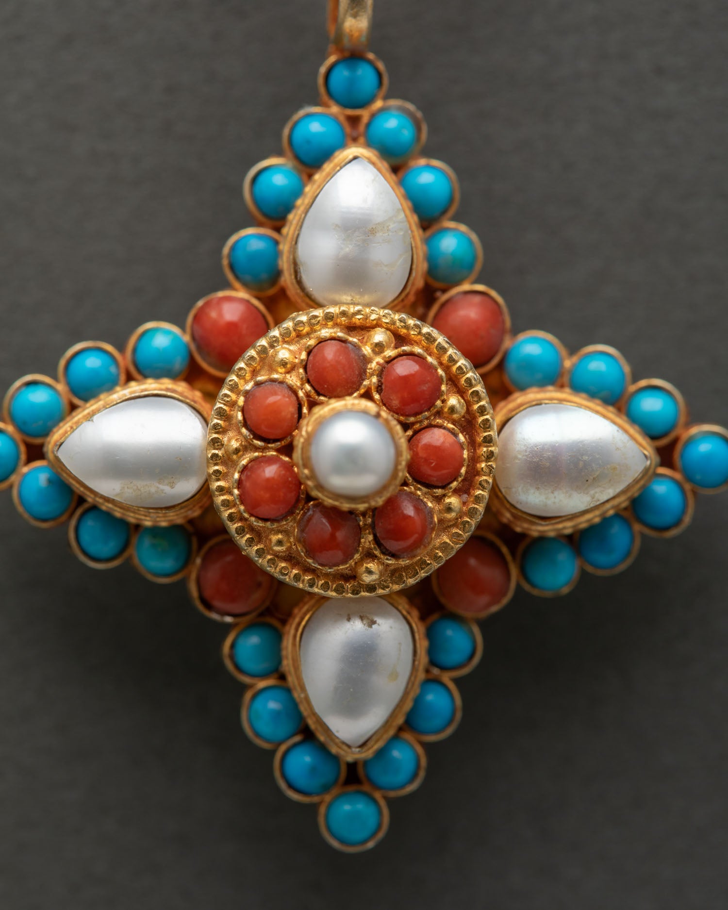 Close up star shaped locket with turquoise coral and pearl stones