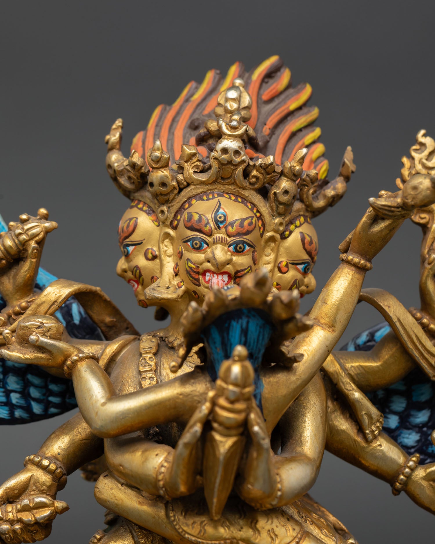 Close up Vajrakilaya three wrathful faces with gold painted detail symbolizing destruction of ignorance obstacles and spiritual defilements in Vajrayana Buddhism