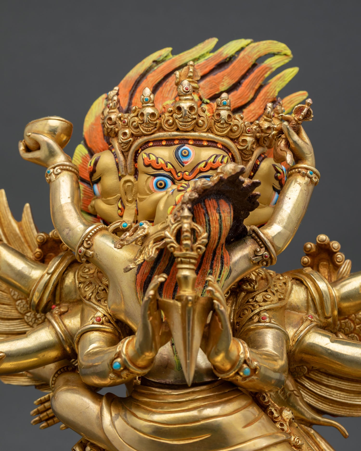 Close up Vajrakilaya wrathful face with turquoise coral stones Himalayan statue
