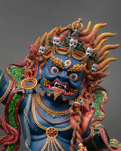 Close up Vajrapani fierce face detail deep blue body piercing eyes fanged expression gold painted ornaments