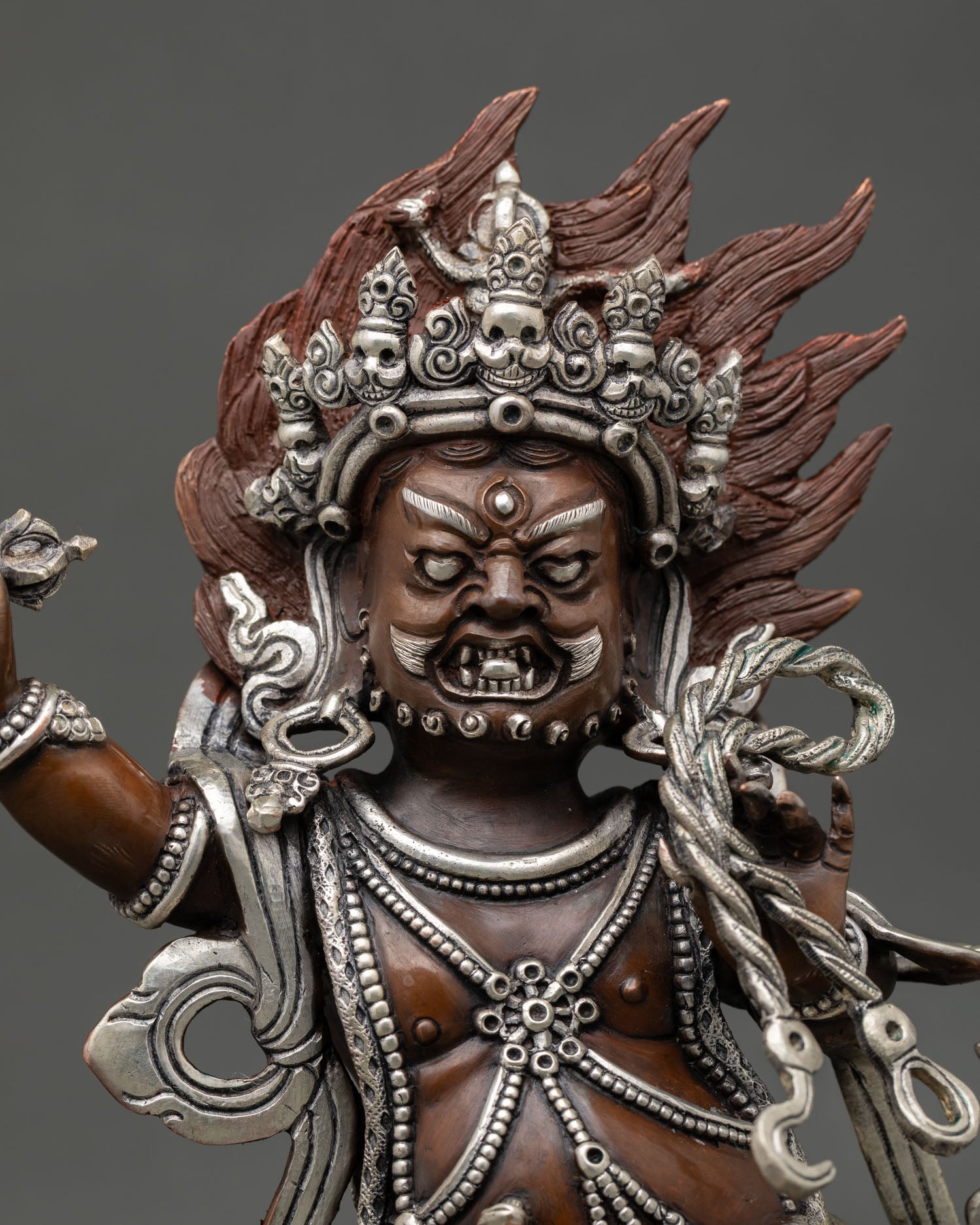 Close up Vajrapani statue fierce expression blazing flame halo intricate Himalayan craftsmanship oxidized copper silver accents Buddhist protector deity