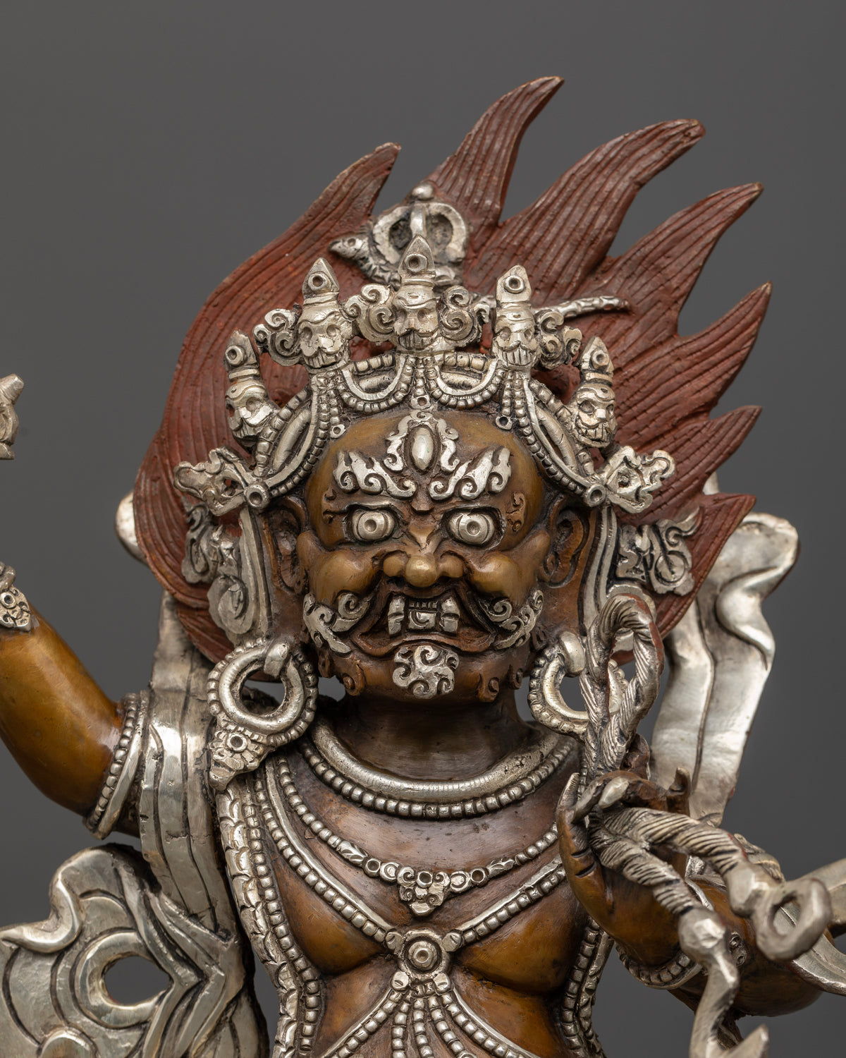 Close up Vajrapani statue showing five skull crown tiger skin and wrathful expression.