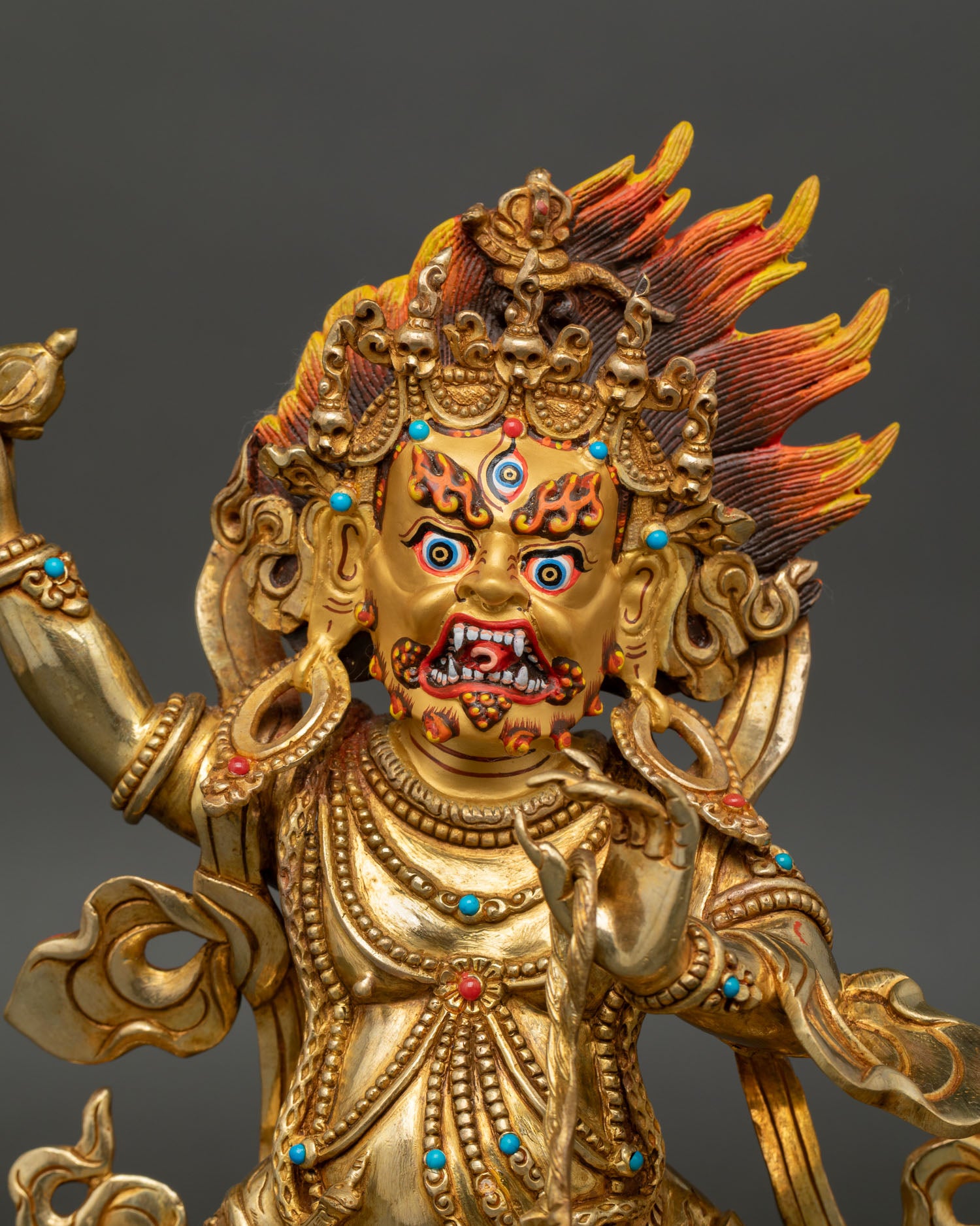 Close up Vajrapani statue with gold painted face wrathful expression and detailed crown adorned with stones
