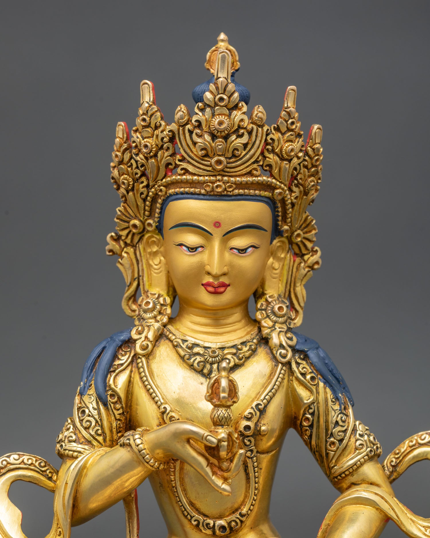 Close up Vajrasattva statue serene face gold painted copper