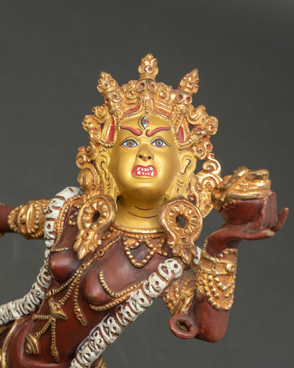 Close-up Vajrayogini gold-painted face details with halo and trident
