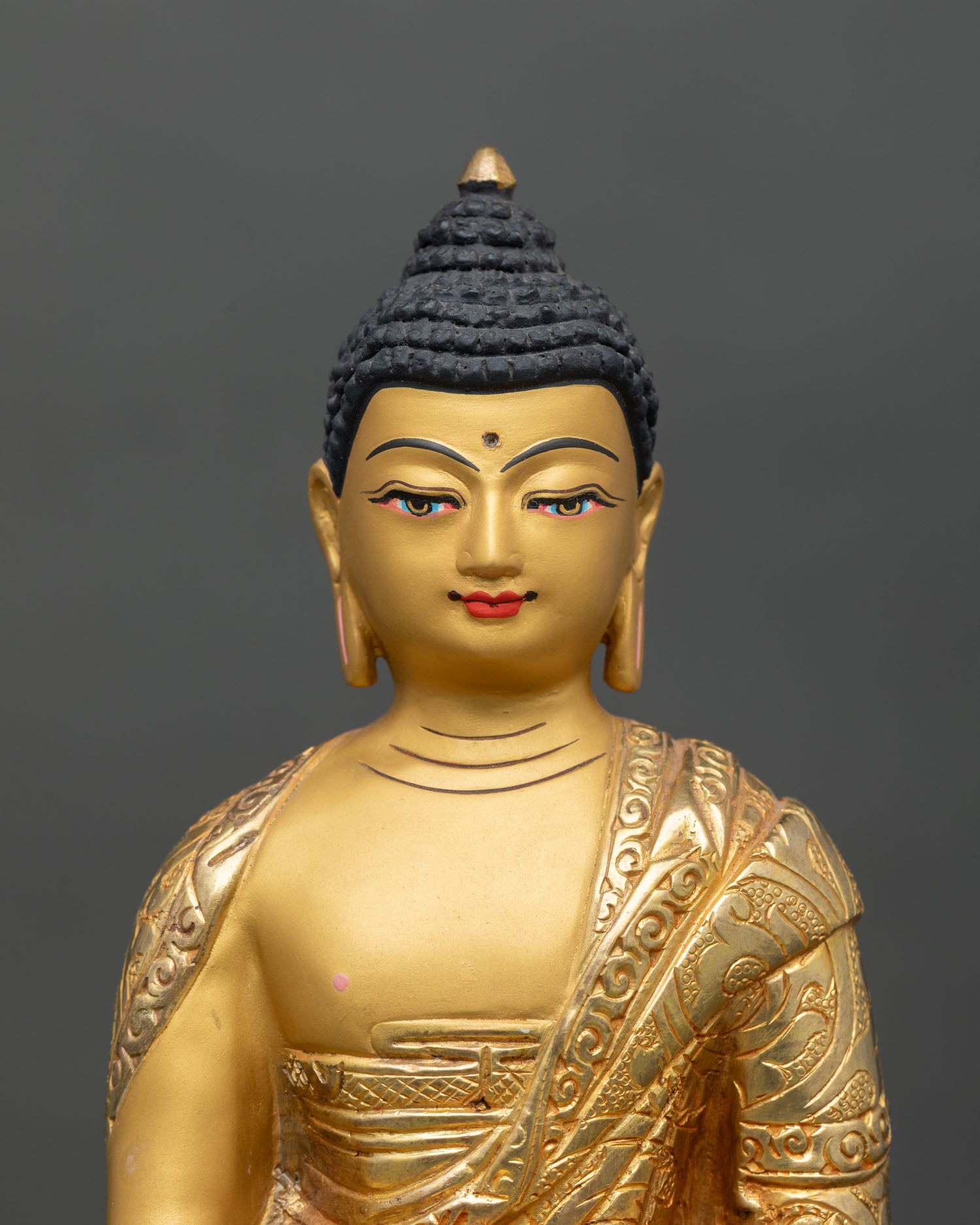 Close up view Buddha face with gold painted serene expression symbolizing enlightenment wisdom and peaceful awakened presence in traditional Himalayan sculpture