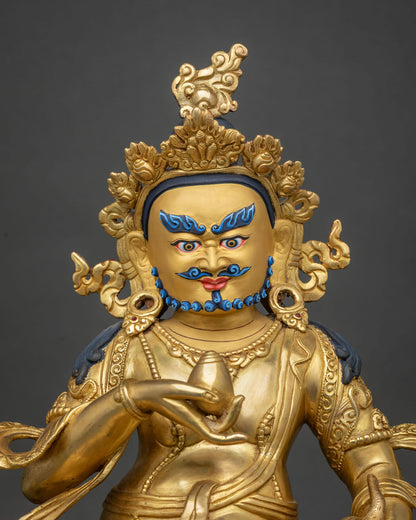 Close-up view of 24K gold-gilded Yellow Dzambhala holding chintamani jewel and mongoose.