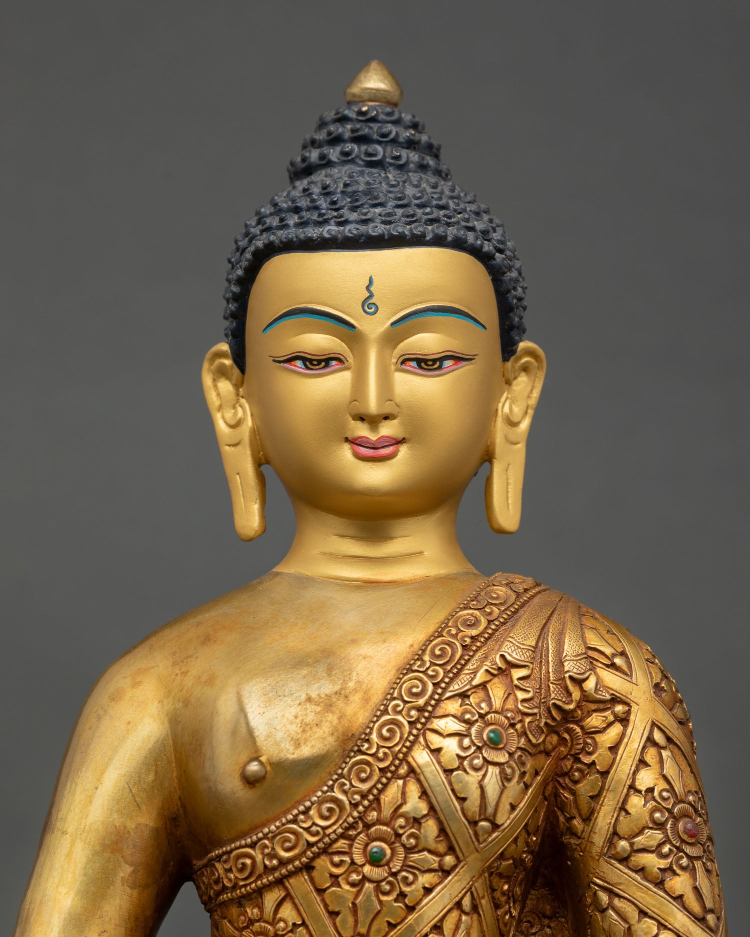 Close up view of Amitabha Buddha sculpture, detailed floral engraved robes and intricate Himalayan craftsmanship