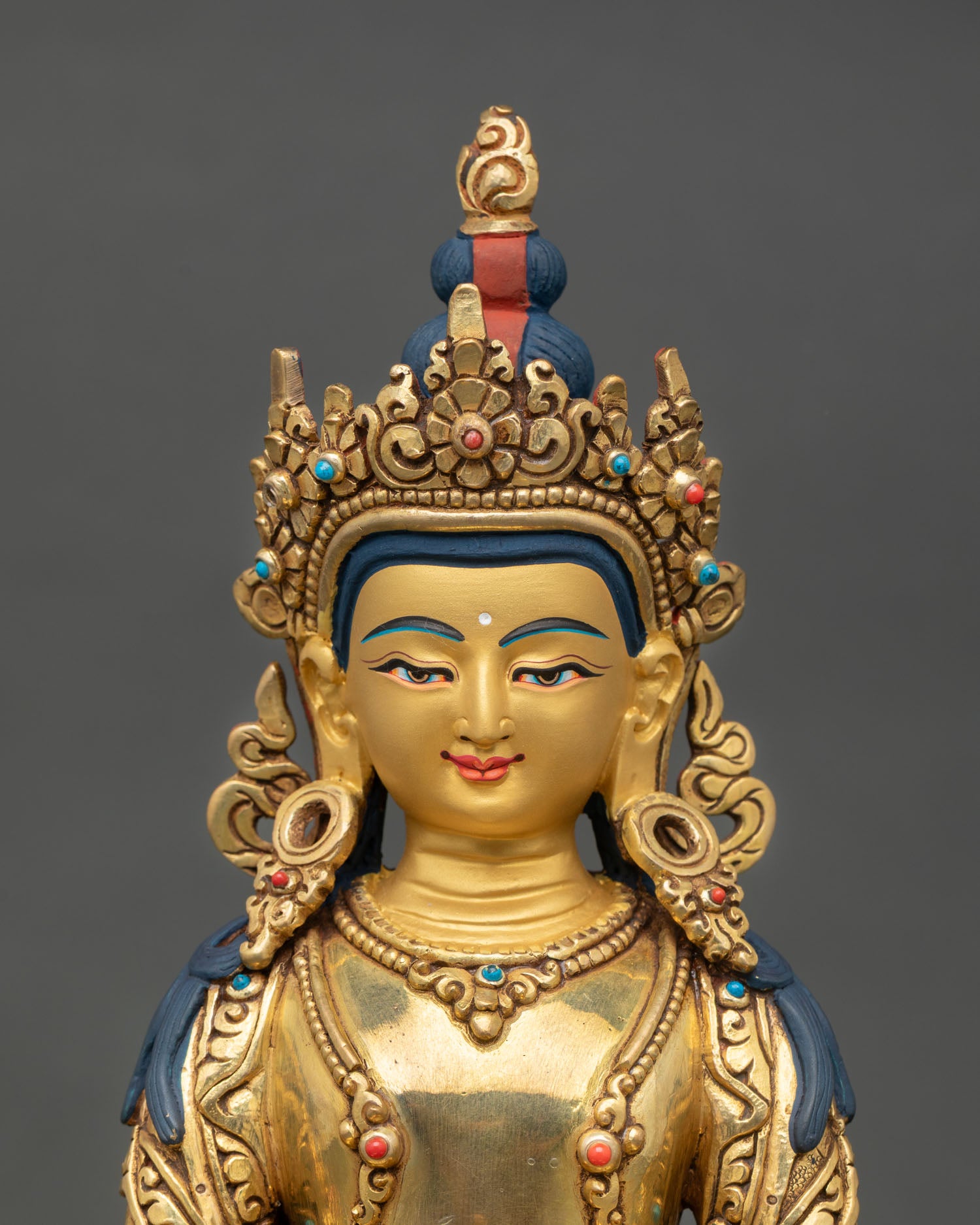 Close up view of Amitayus Buddha statue showing detailed gold painted face, semi precious stone ornaments, and intricate Himalayan Newari craftsmanship