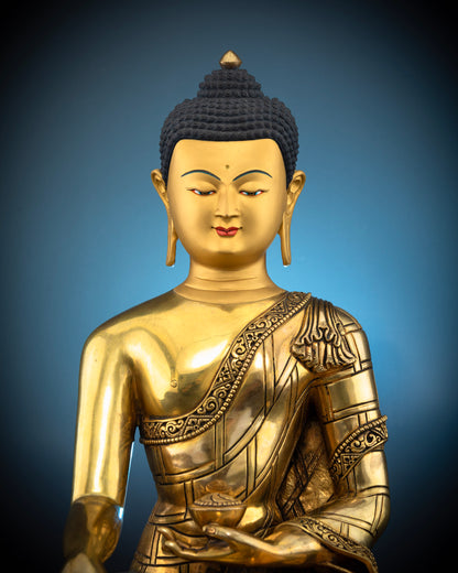 Close-up view of Buddha Shakyamuni statue featuring a calm gold-painted face and detailed traditional Nepalese Buddhist carvings