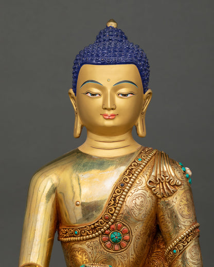 Close up view of Buddha Shakyamuni statue featuring a serene gold painted face, semi precious stones, and traditional Buddhist artistry.