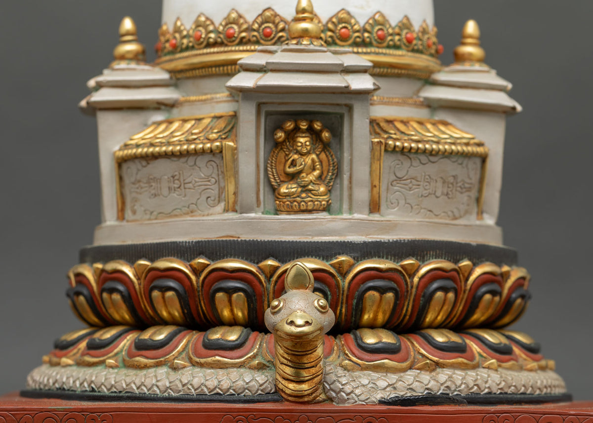 Close up view of Buddhist chorten stupa showing lotus base, gold-gilded borders and serpent protector