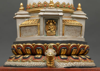 Close up view of Buddhist chorten stupa showing lotus base, gold-gilded borders and serpent protector
