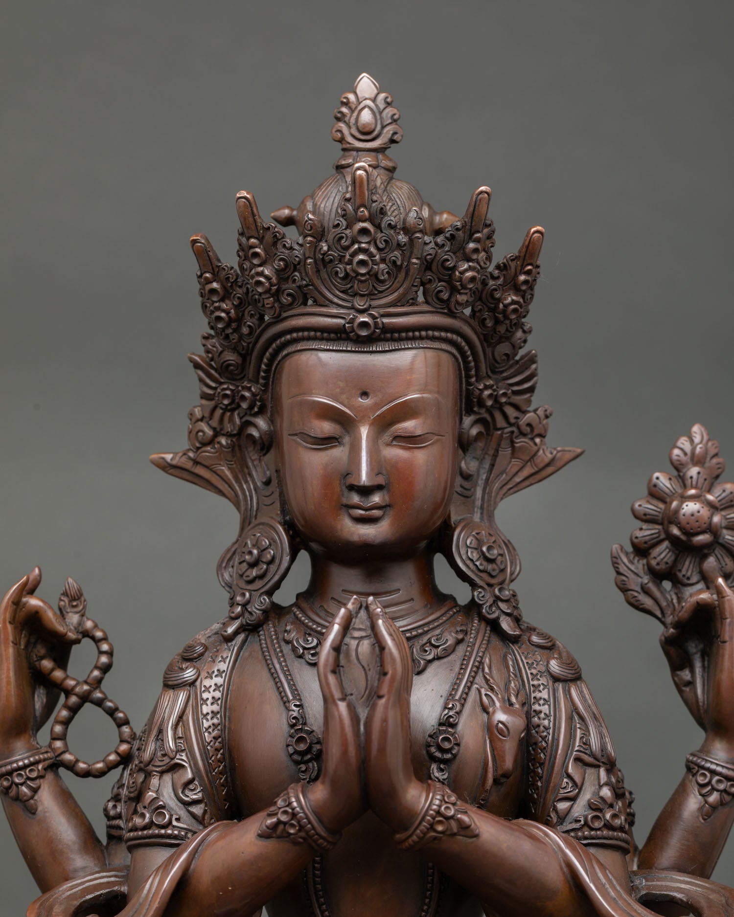Close up view of Chenrezig sculpture showing gently closed eyes, detailed facial features