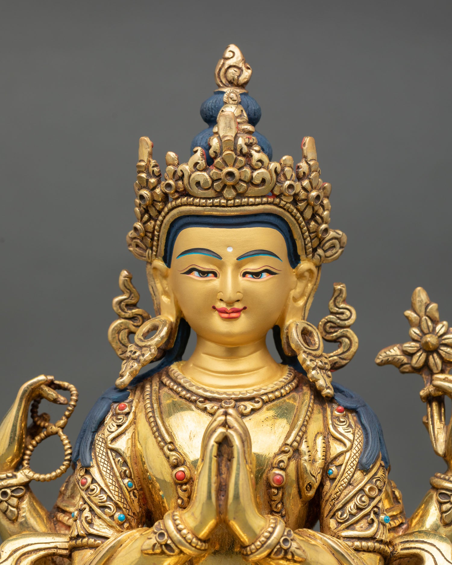 Close up view of Chenrezig statue showing hand painted face and detailed gold jewelry work in traditional Newari craftsmanship