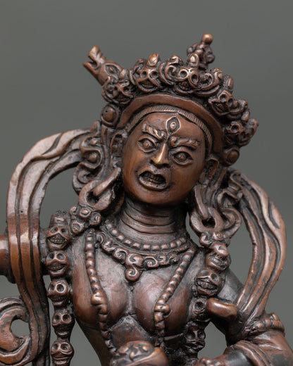 Close up view of Dorje Phagmo face with flaming halo and jeweled crown, sacred Vajrayana goddess statue crafted in copper by Nepalese artisans.