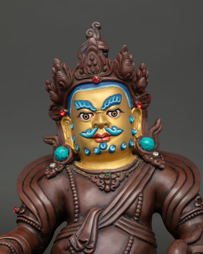 Close up view of Dzambhala Buddhist wealth deity statue with semi precious stone details.