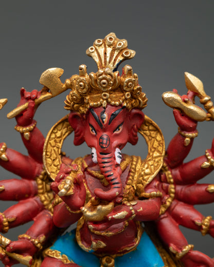 Close up view of Ganesh deity statue showing intricate facial features gold gilded ornaments and sacred attributes in multiple arms