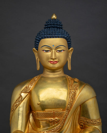 Close-up view of gold gilded Shakyamuni Buddha statue showing detailed robe and serene expression