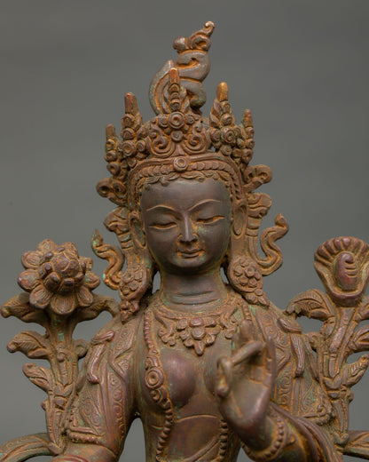 Close-up view of green tara bodhisattva statue showing intricate copper details and antique finish