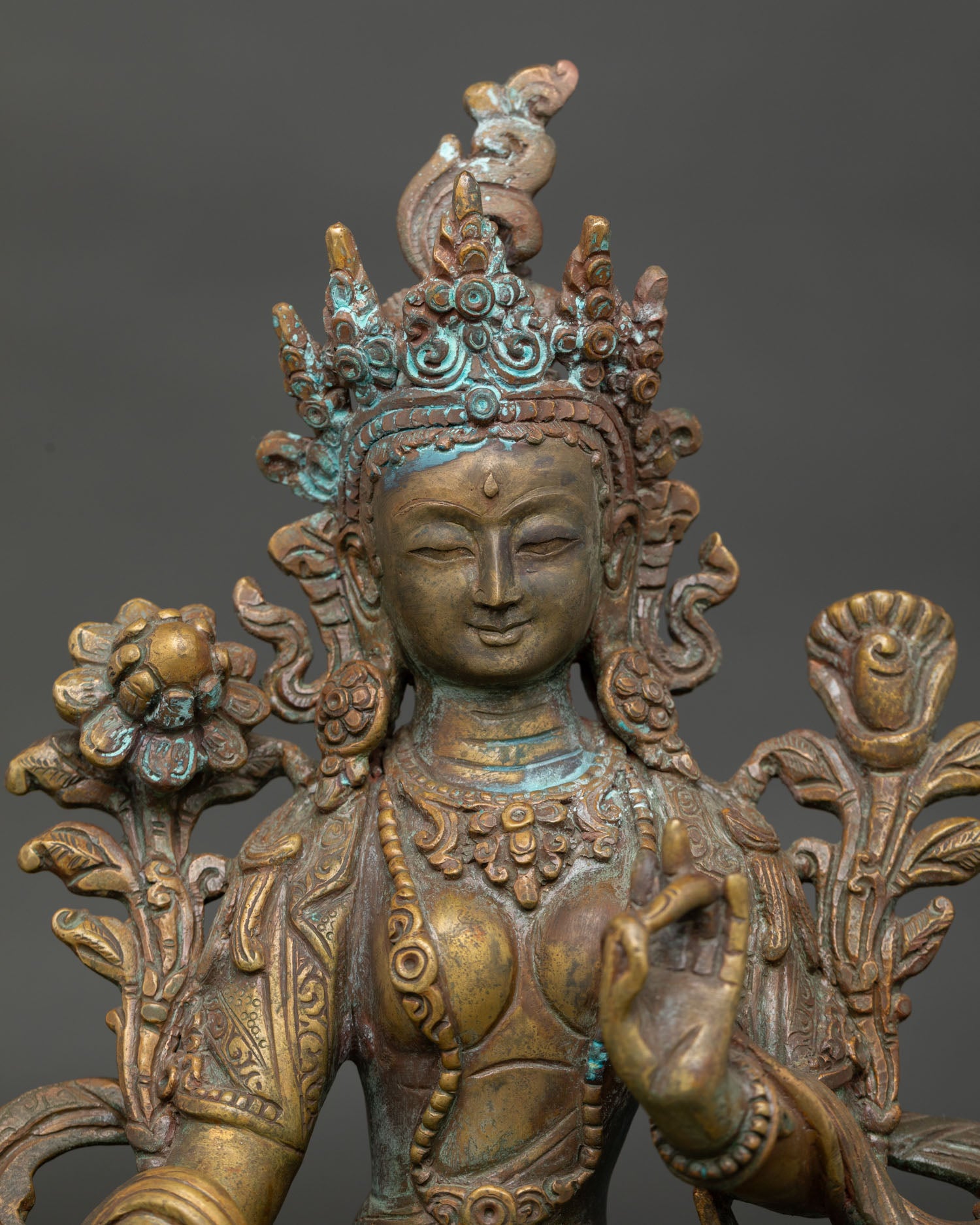 close up view of green tara drolma statue showing intricate copper craftsmanship and antique details
