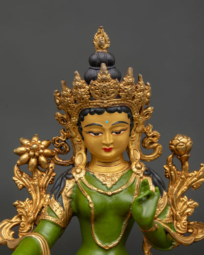 Close up view of Green Tara statue showing 24K gold painted face and gilded details.