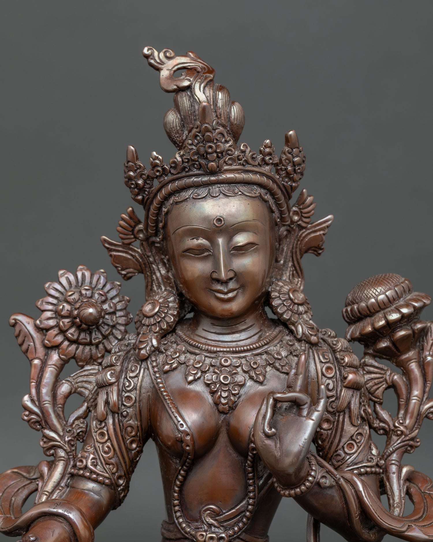 Close-up view of Green Tara statue with hand-carved robe and jeweled crown
