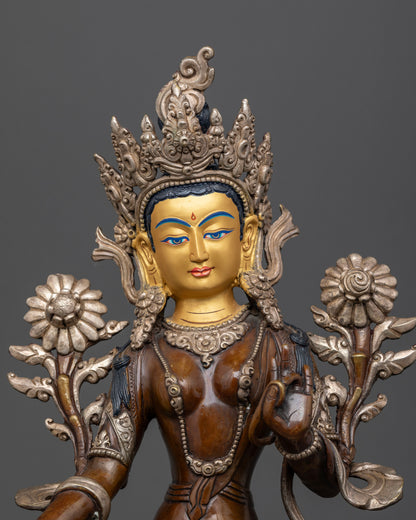 Close up view of Green Tara with gold painted face and Varada Vitarka Mudras