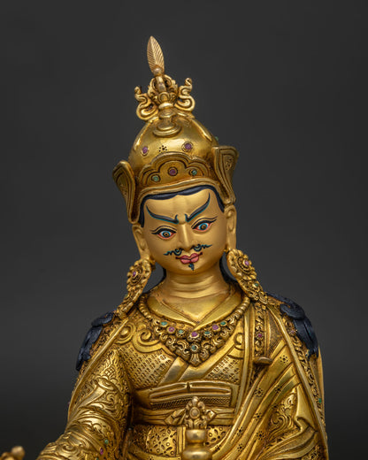 Close up view of Guru Rinpoche face with gold painted details and semi precious stone inlays