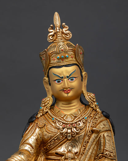 Close up view of Guru Rinpoche statue showing detailed gold painted face and semi precious stone embellishments with sacred Himalayan craftsmanship