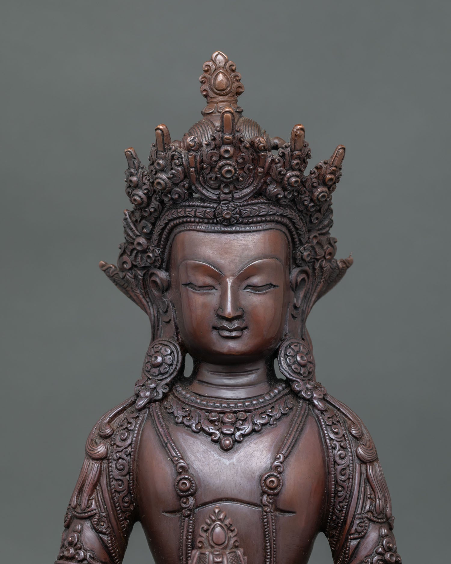Close-up view of handcrafted Amitayus Buddha statue showing oxidized copper patina detail