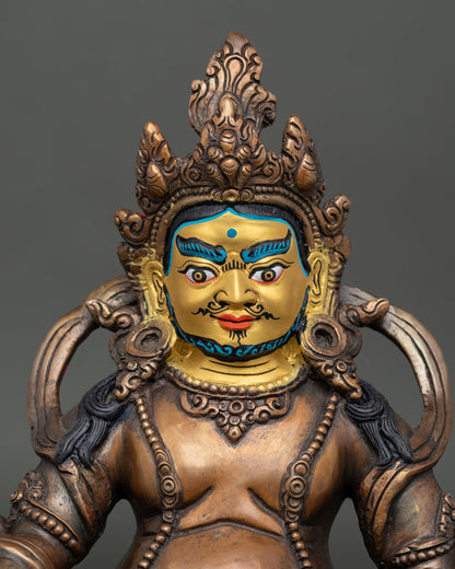 Close-up view of a handcrafted Dzambhala statue with a gold-painted face and intricate Nepalese Buddhist artistry.