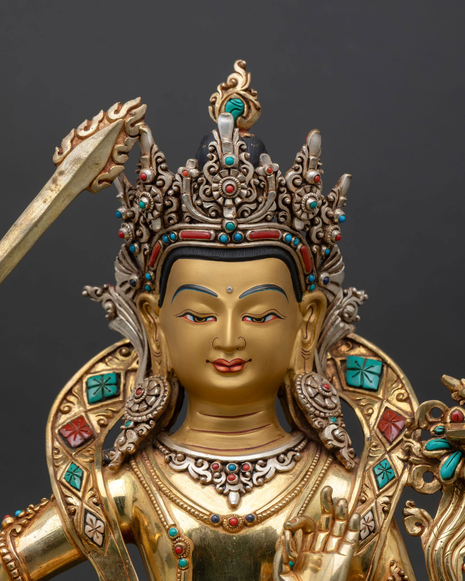 Close-up view of Manjushri statue, handcrafted lost wax copper details, gold gilded finish from Nepal