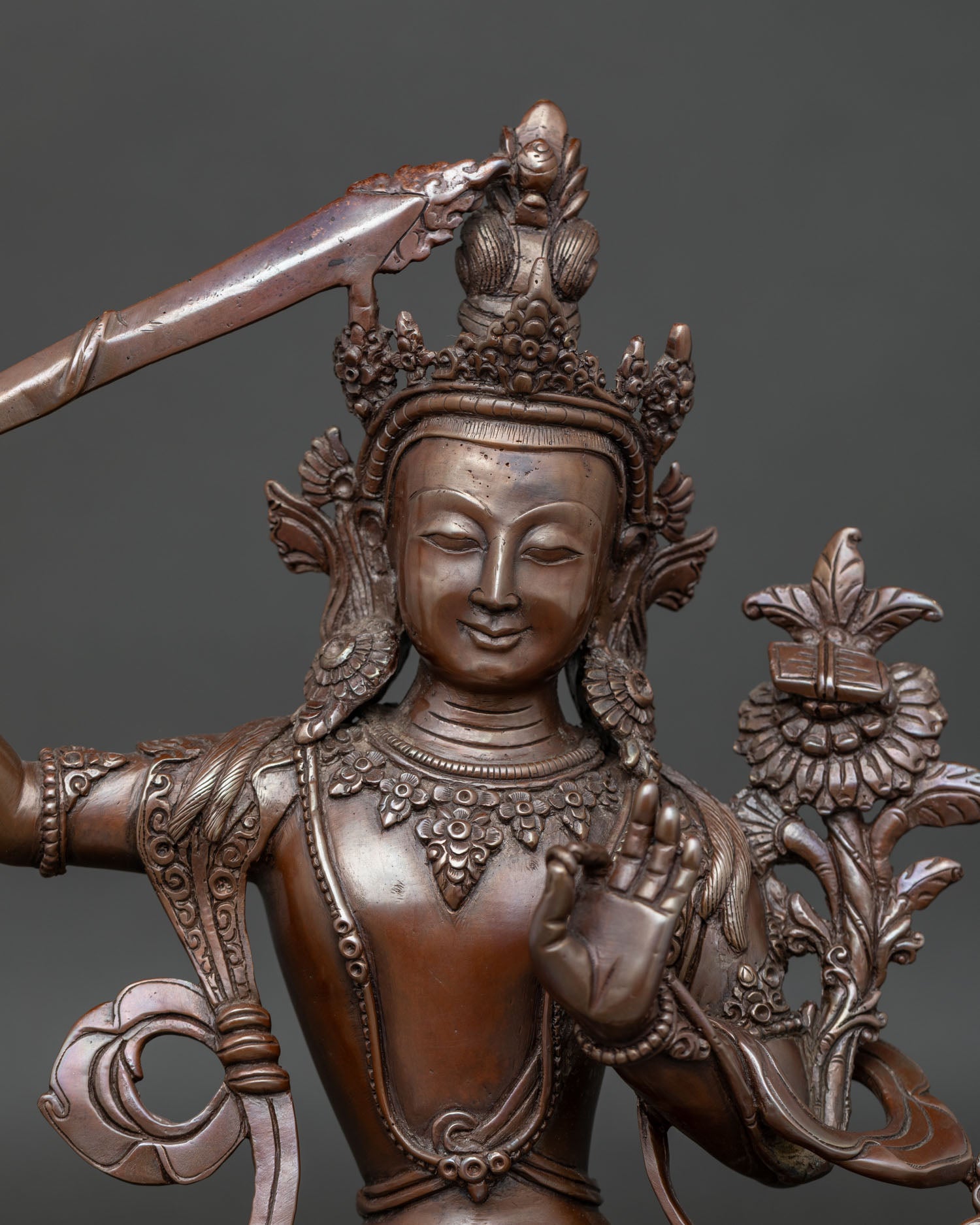 Close-up view of Manjushri statue with Prajnaparamita Sutra and lotus flower