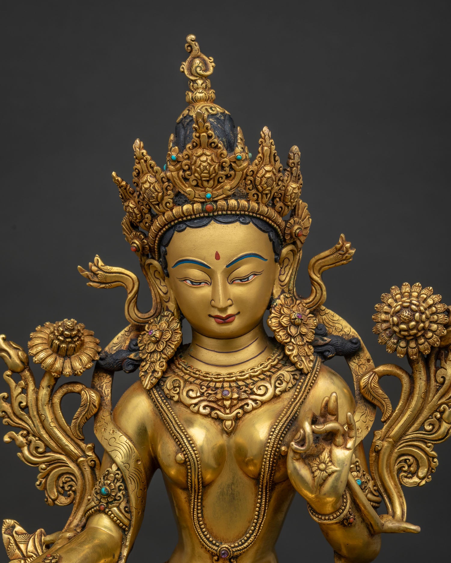 Close up view of Nepalese Green Tara statue with intricate gold gilding details