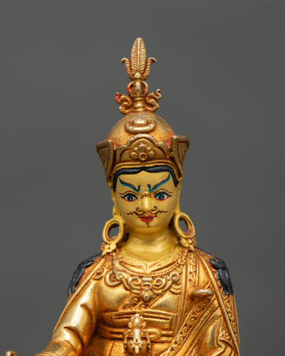 Close up view of Padmasambhava sculpture showing vajra skull cup and detailed facial expression with intricate gold gilding and Himalayan Newari craftsmanship