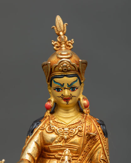 Close-up view of Padmasambhava statue showing expressive facial details, intricate gold craftsmanship on the copper surface