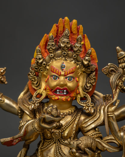 Close-up view of Red Dzambhala statue with detailed gold painted face