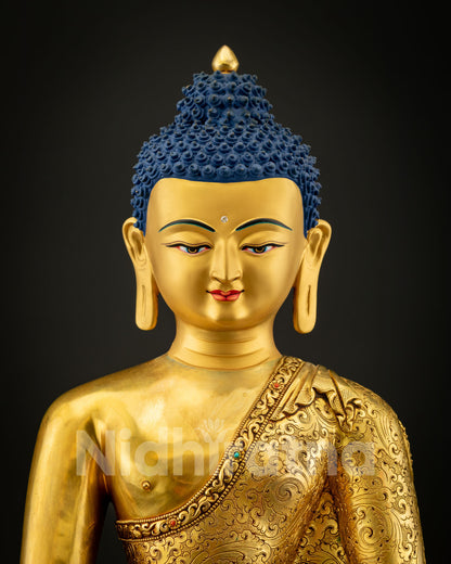 Close-up view of Shakyamuni Buddha Statue showing serene gold-painted face with peaceful expression symbolizing wisdom, compassion, and meditation.