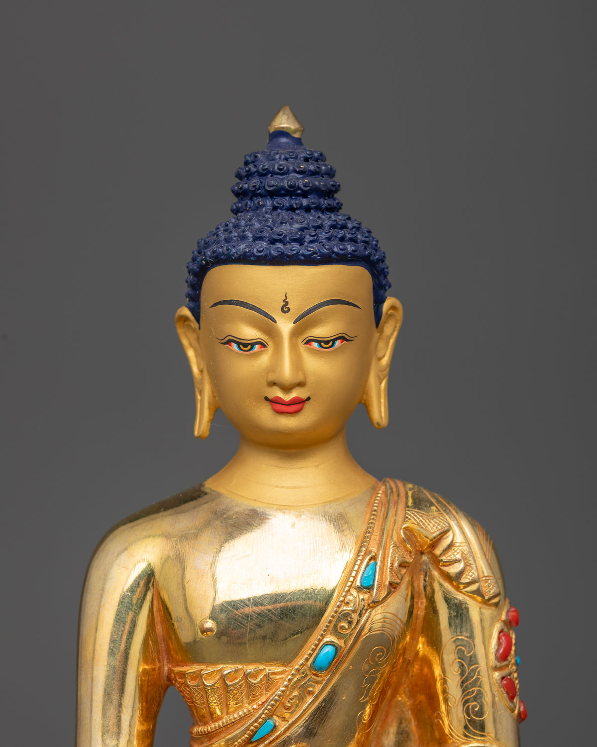Close up view of Shakyamuni Buddha Statue with 24K gold painted face floral robe carvings and jeweled details