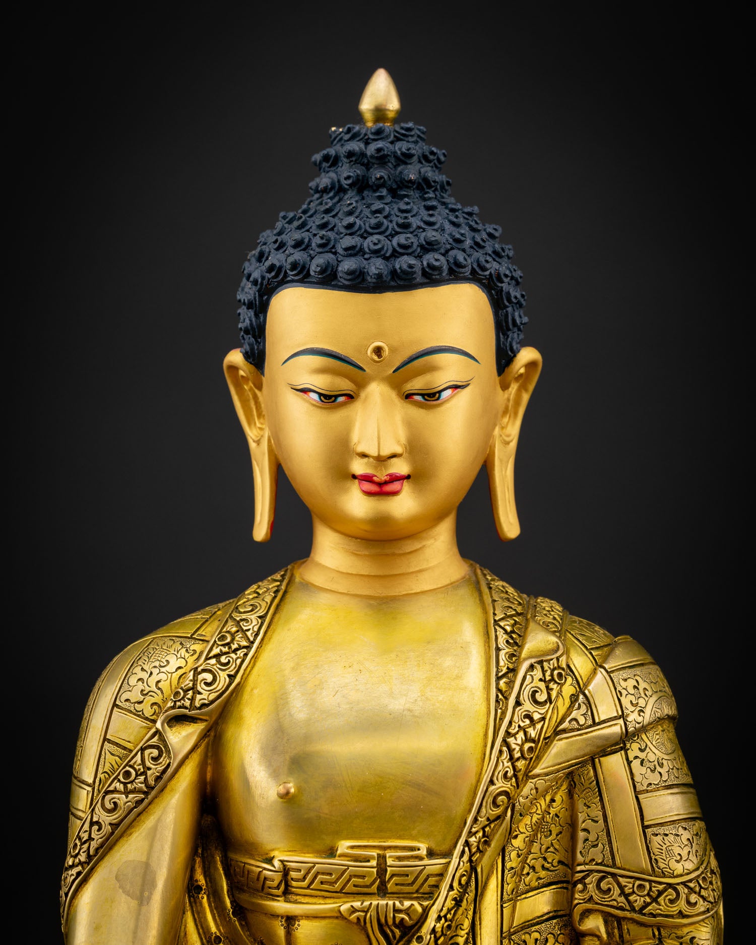 Close up view of Shakyamuni Buddha statue with serene gold painted face and detailed craftsmanship