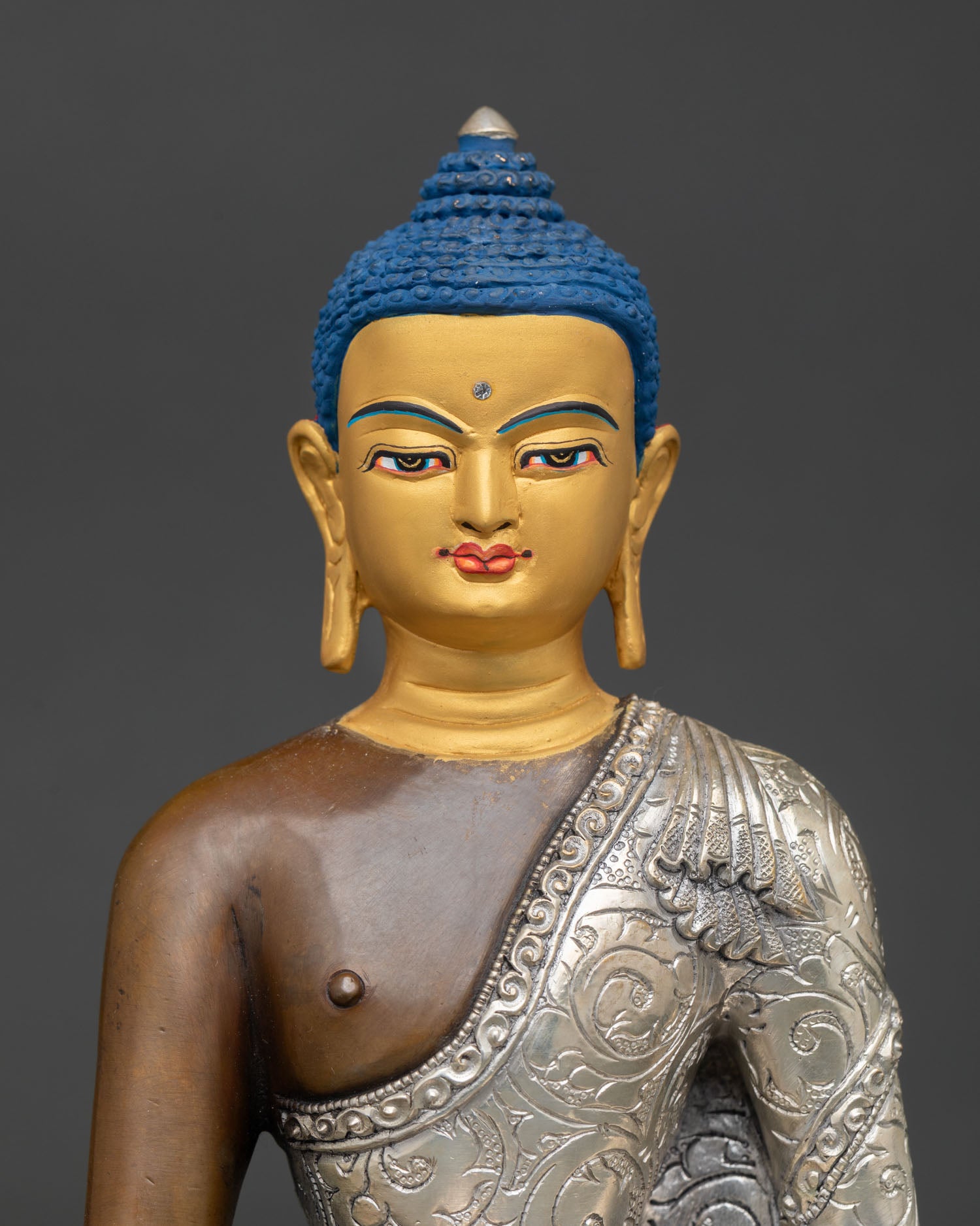 Close up view of the gold-painted face on a Himalayan Shakyamuni Buddha meditation statue
