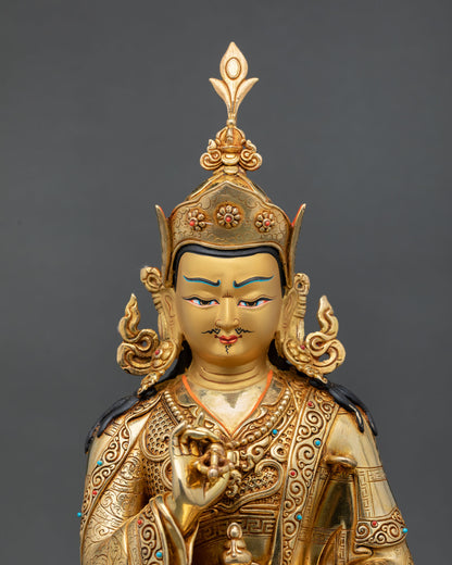 Close up view of Tsokye Dorje statue showing detailed gold painted face with turquoise and coral stone inlays and sacred Buddhist symbolism